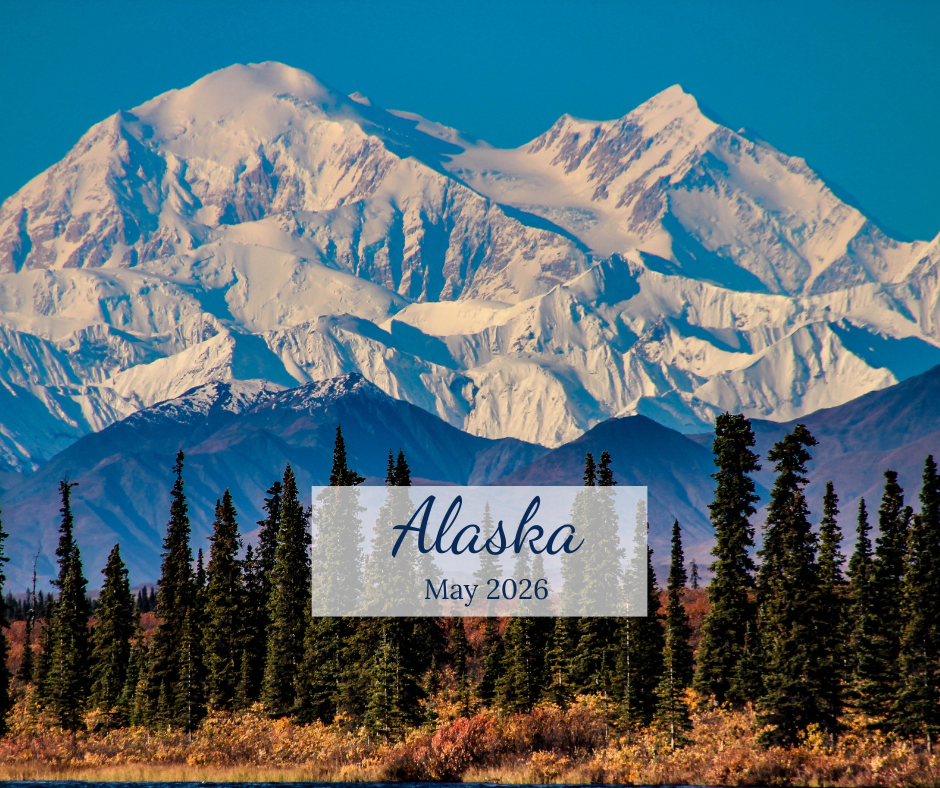 Snow covered mountains in the background with pine trees in the foreground overlaid with Alaska May 2026