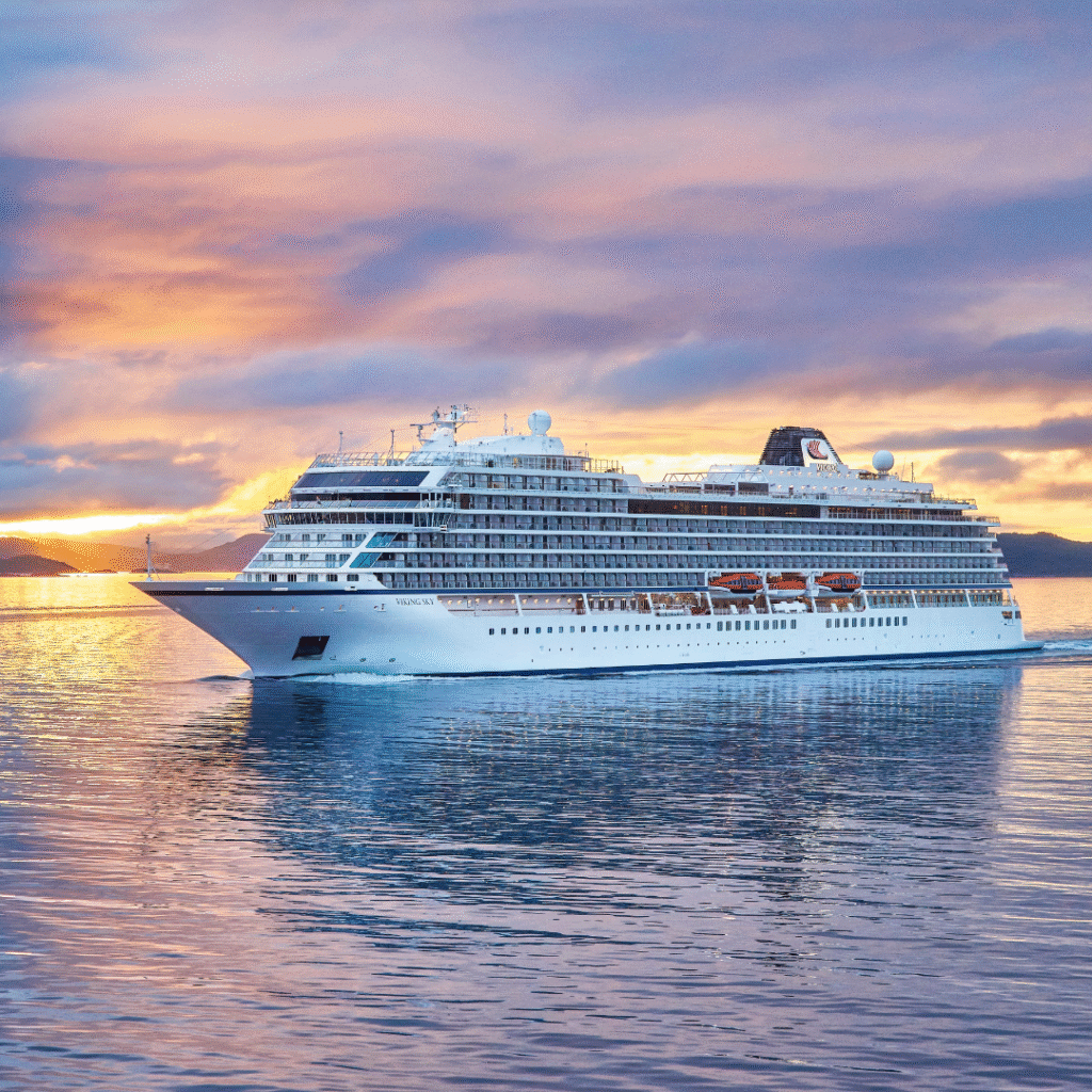 Viking Sky cruise ship sailing with a sunset in the background
